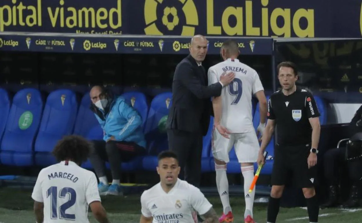 Zinedine Zidane da una palmada a Benzema tras la salida del campo del delantero. 