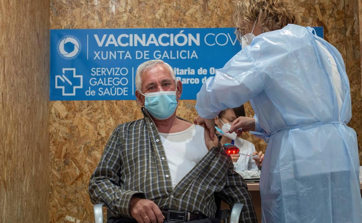 Una sanitaria vacuna a un hombre en Ourense.