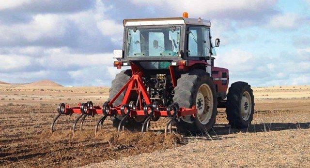 Imagen de archivo de un tractor arando la tierra. 