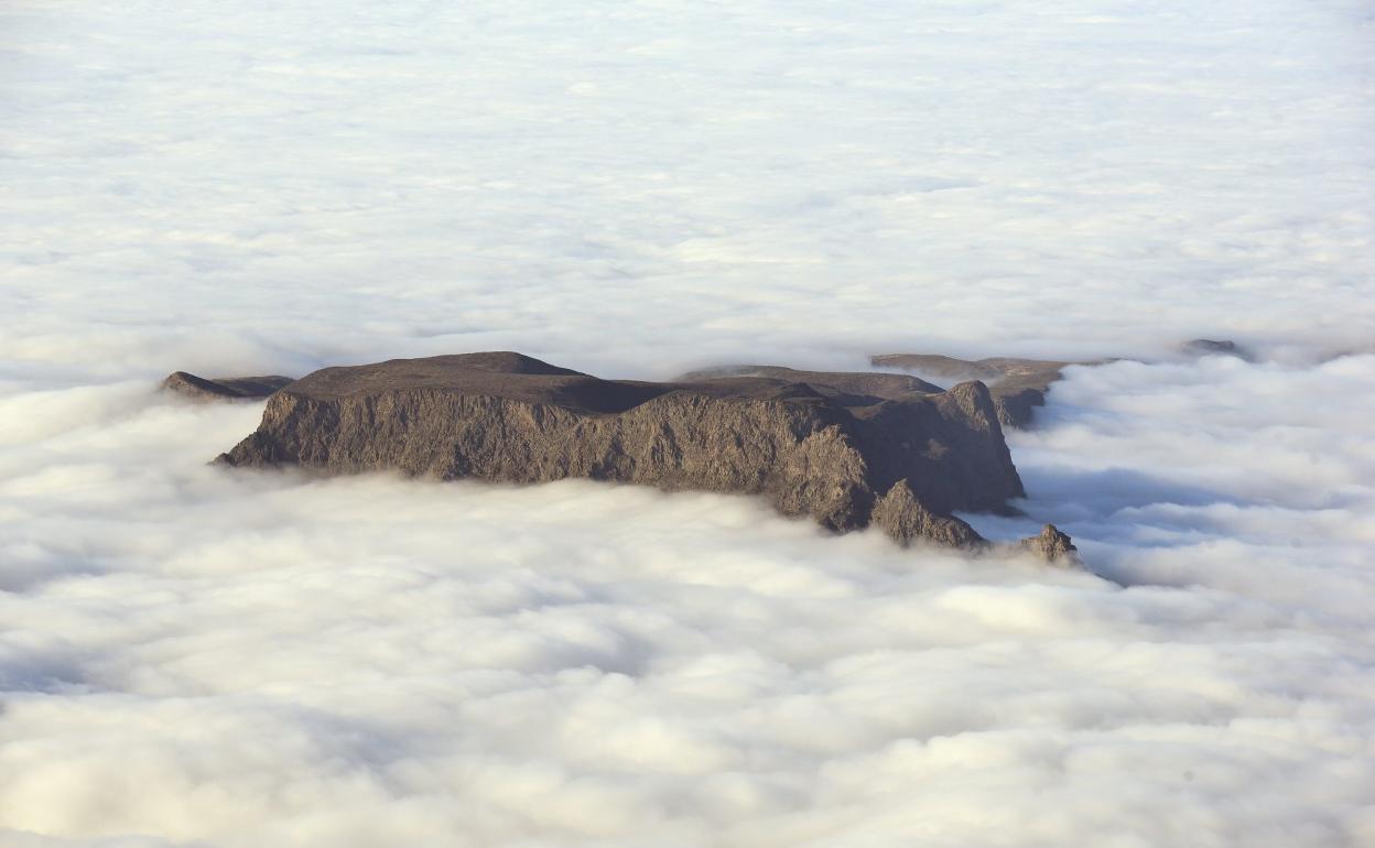 Imagen de archivo del macizo de Amurga sobresaliendo entre un mar de nubes. 
