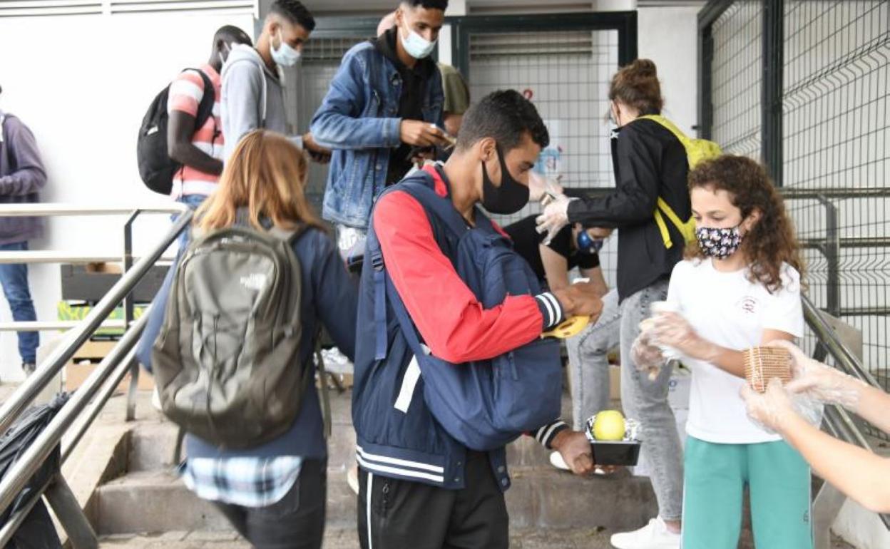 Voluntarios de la plataforma Somos Red reparten bocadillos en la playa de Las Alcaravarneras. 