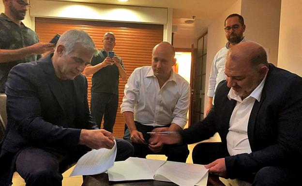 Yair Lapid, Naftali Bennett y Mansour Abbas, de izquierda a derecha, durante la firma del acuerdo.