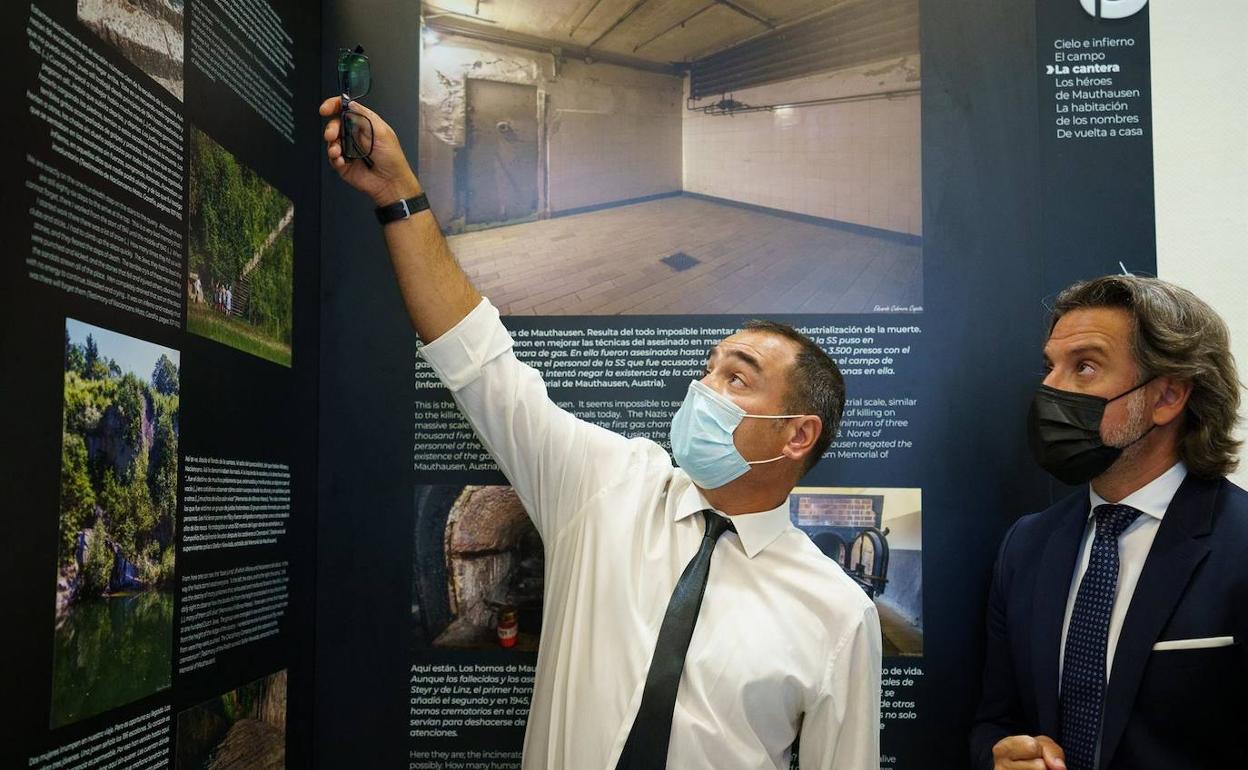 El periodista y escritor Eduardo Cabrera (i) conversa con el presidente del Parlamento de Canarias, Gustavo Matos (d), durante el acto de homenaje a las víctimas canarias del holocausto nazi e inauguración de la exposición «186 escalones, en memoria de los canarios de Mauthausen. 1945-2021».
