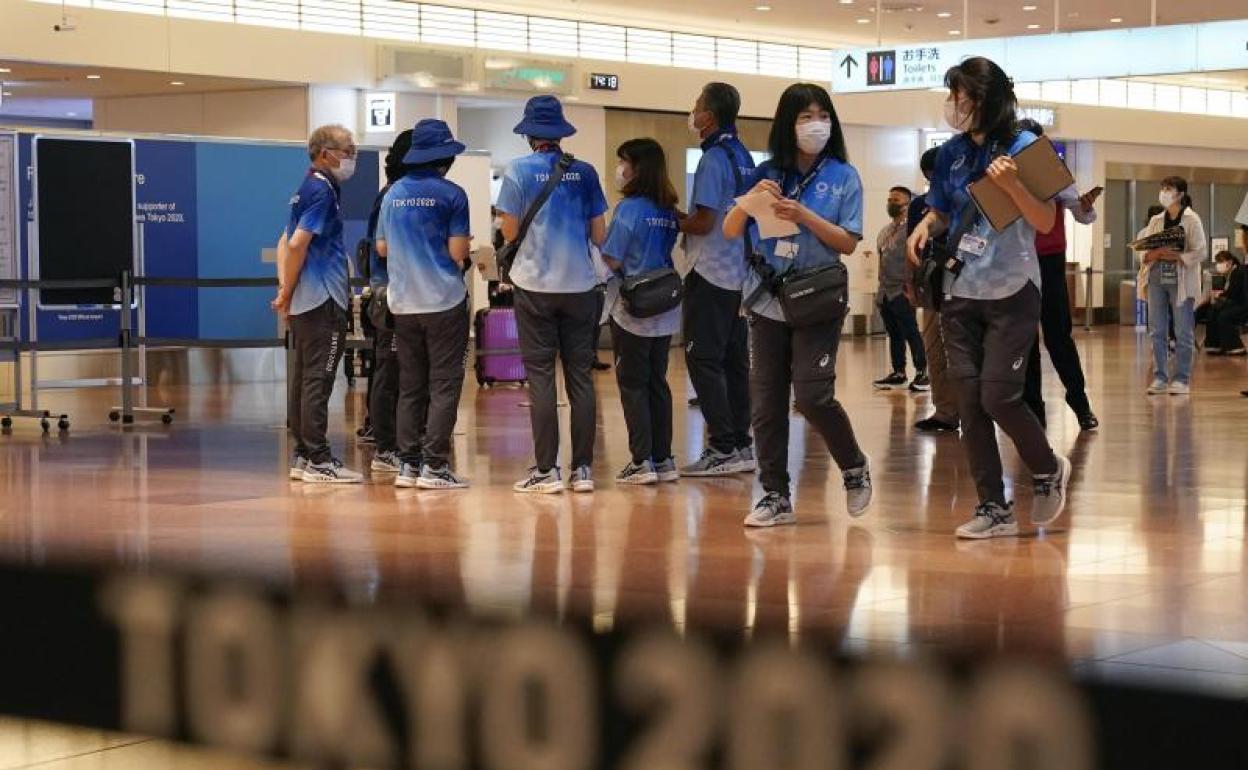 Voluntarios en el Aeropuerto de Tokio esperan la llegada de Thomas Bach. 