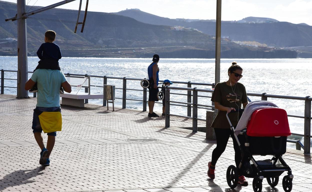 Imagen de archivo varias personas paseando con niños en el paseo de Las Canteras. 