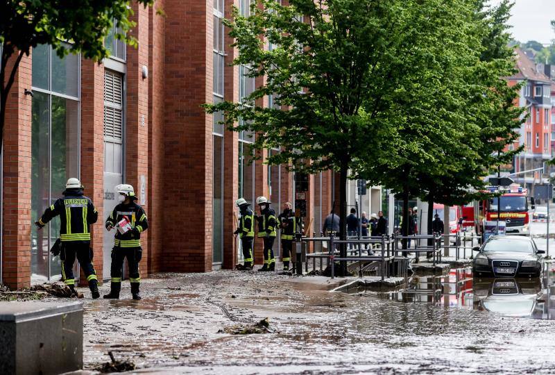 Bomberos actuando en una calle inundada en la ciudad de Hagen, Alemania.