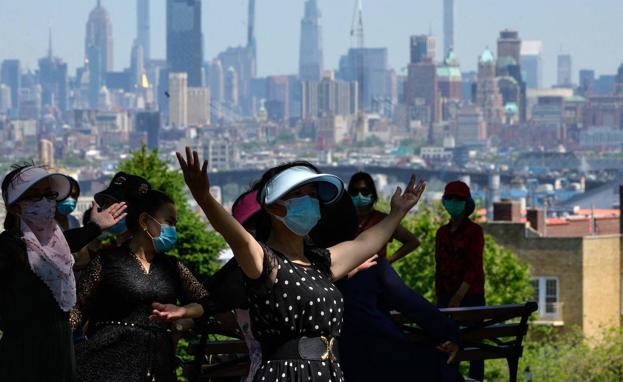 Un grupo de mujeres se divierte en un parque de Nueva York, con el 'skyline' de Manhattan al fondo.