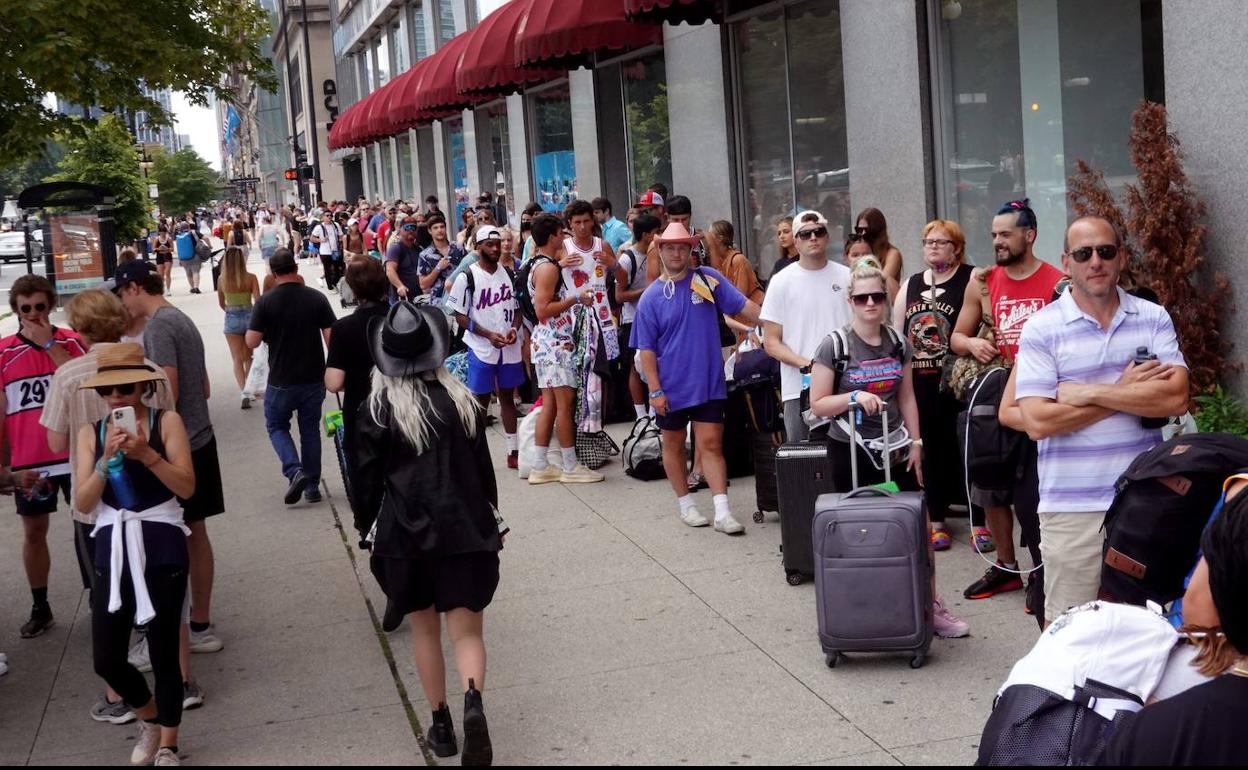 Centenares de asistentes al festival de música Lollapalooza esperaban este viernes a hacerse el control sanitario para entrar en su hotel en Chicago.