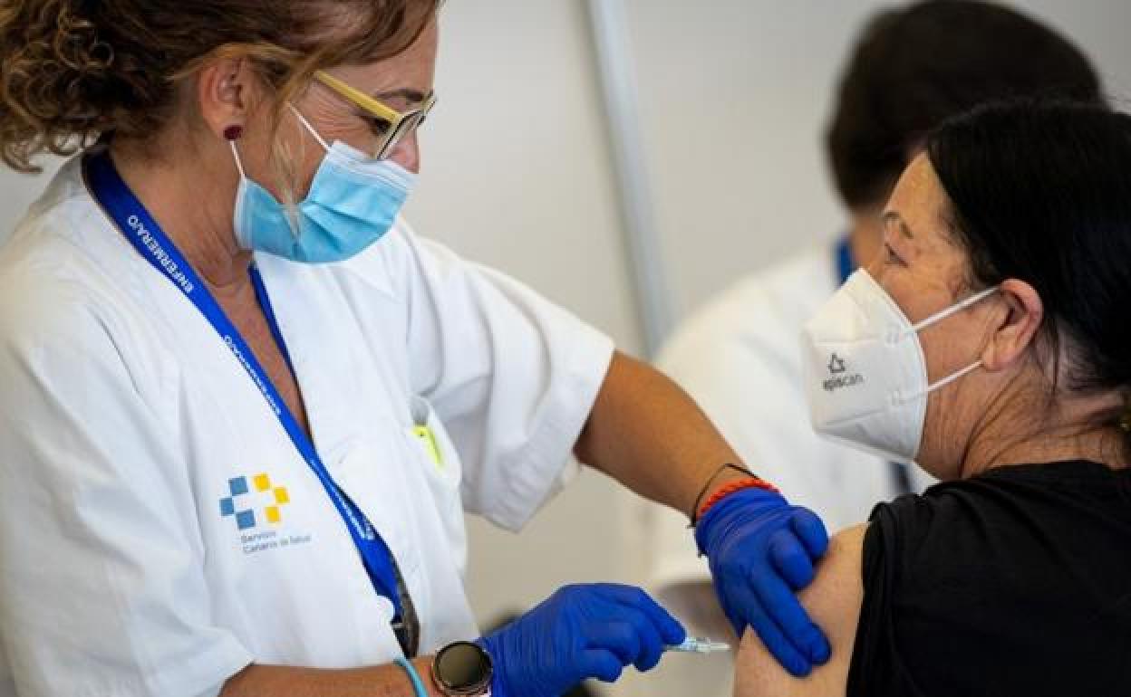Una enfermera vacuna a una mujer. 