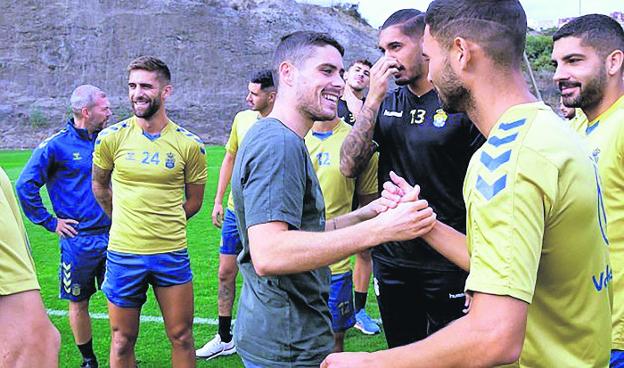 Sergio Ruiz saluda, sonriente, a Benito, una vez finalizada su intervención para anunciar a sus compañeros el problema que atraviesa y que le impide seguir jugando .