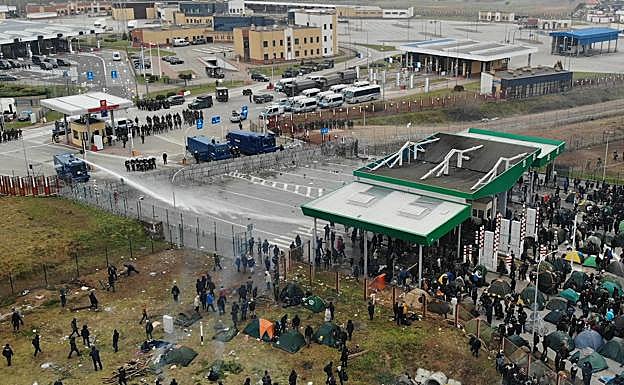 Las fuerzas de seguridad polacas dispersan con cañones de agua a los inmigrantes que les atacan desde territorrio bielorruso, que esperan para saltar las vallas.