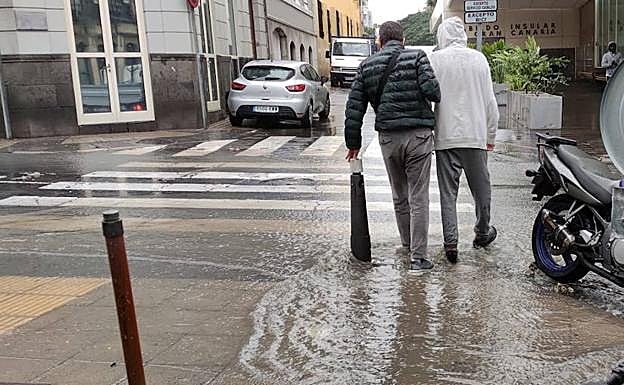 Imagen principal - Charcos en la calle Buenos Aires esquina Pérez Galdós. El interior de la Óptica Checa con agua