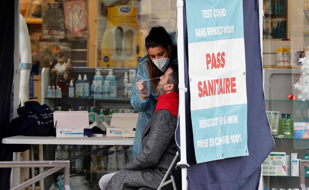 Una farmeceutica de París realiza una prueba de contagio a uno de sus clientes. 
