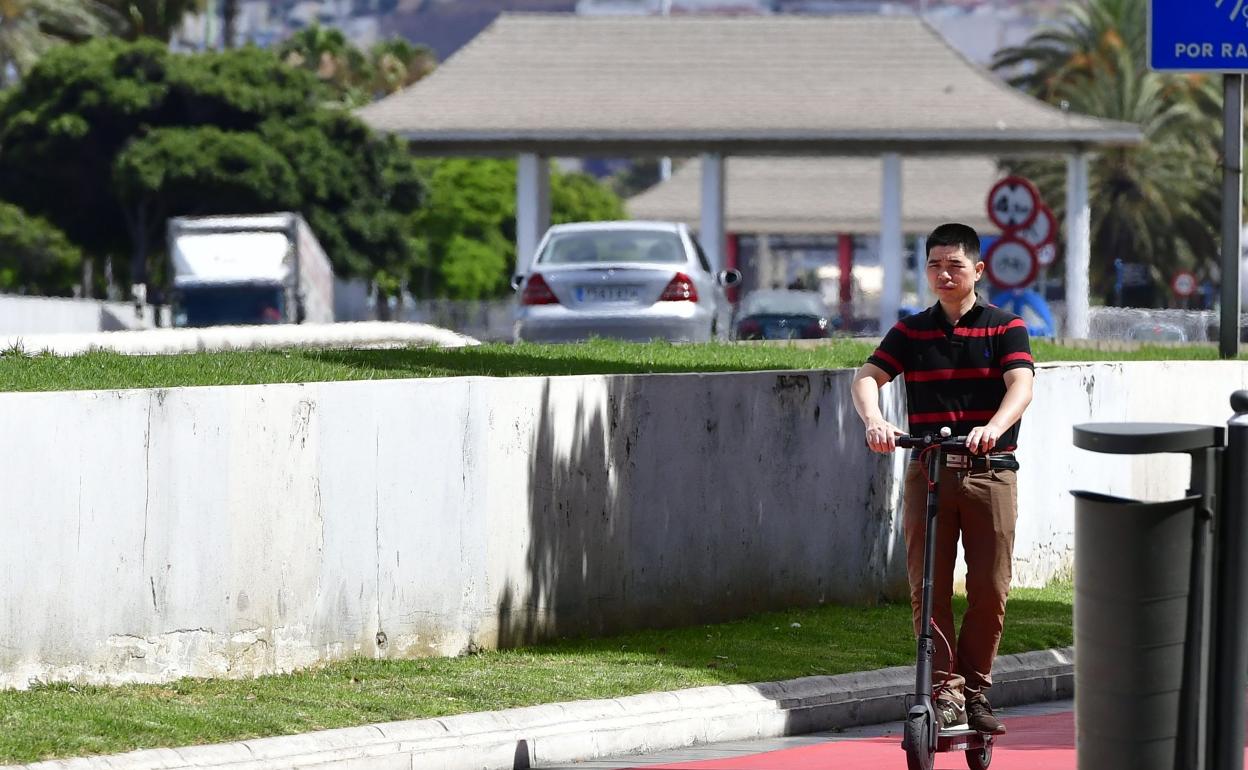 Un ciudadano circula en patinete por la ciudad, en una foto tomada antes de la pandemia. 