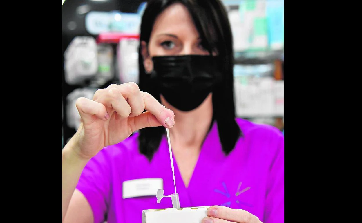 Una trabajadora de una farmacia hace un test de antígenos. 