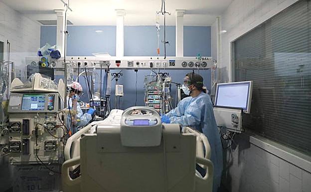 Imagen de archivo de un enfermo atendiendo a un paciente en la UCI de un hospital. 