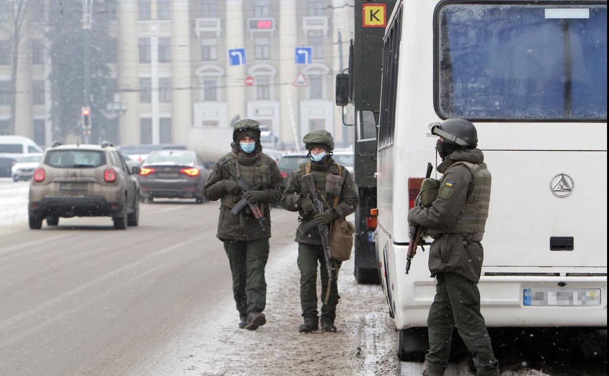 Miembros de la Guardia Nacional de Ucrania patrullan por una avenida de Dnipro.