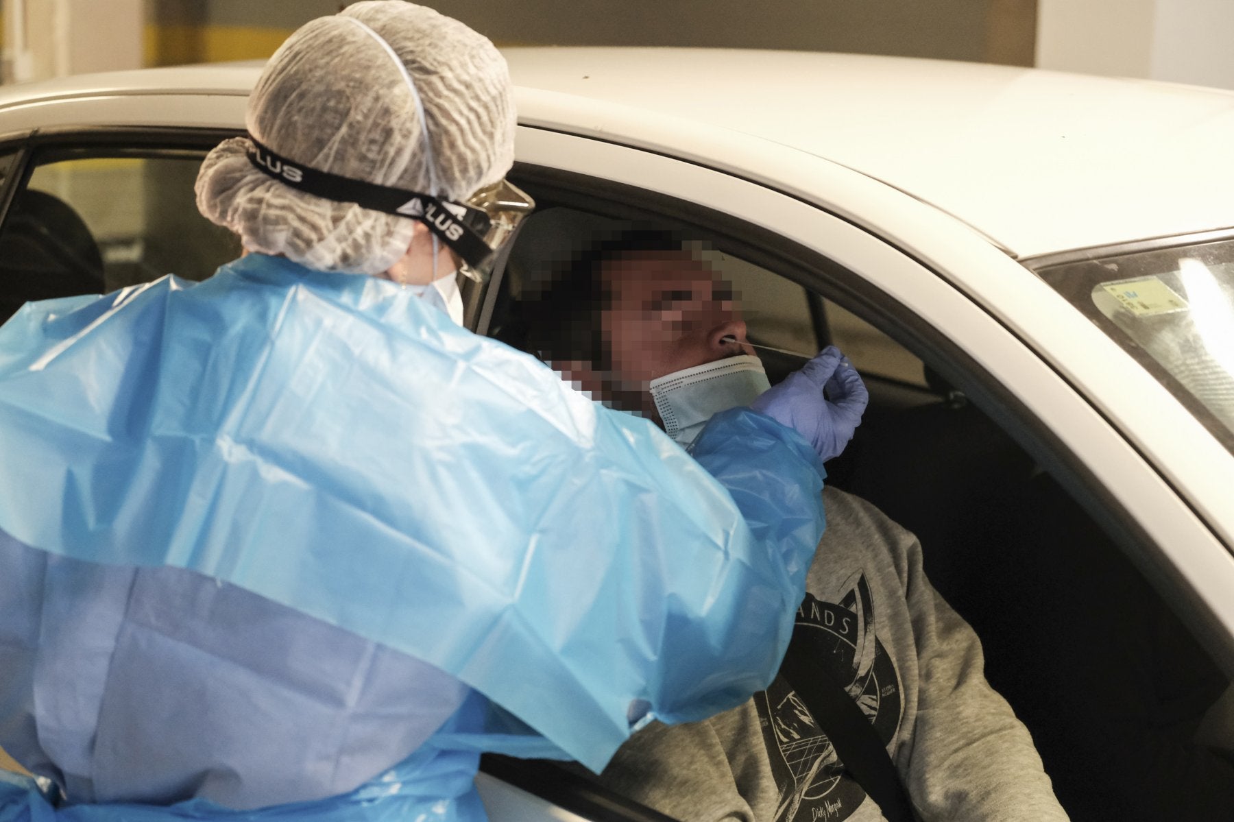 Foto de archivo de una sanitaria recogiendo muestras a un hombre para hacer una PCR. 
