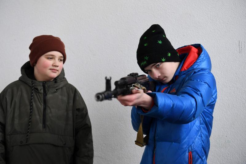 Dos adolescentes aprenden a manejar un AK-47 de asalto durante los cursos de autodefensa en Lviv, al oeste de Ucrania.