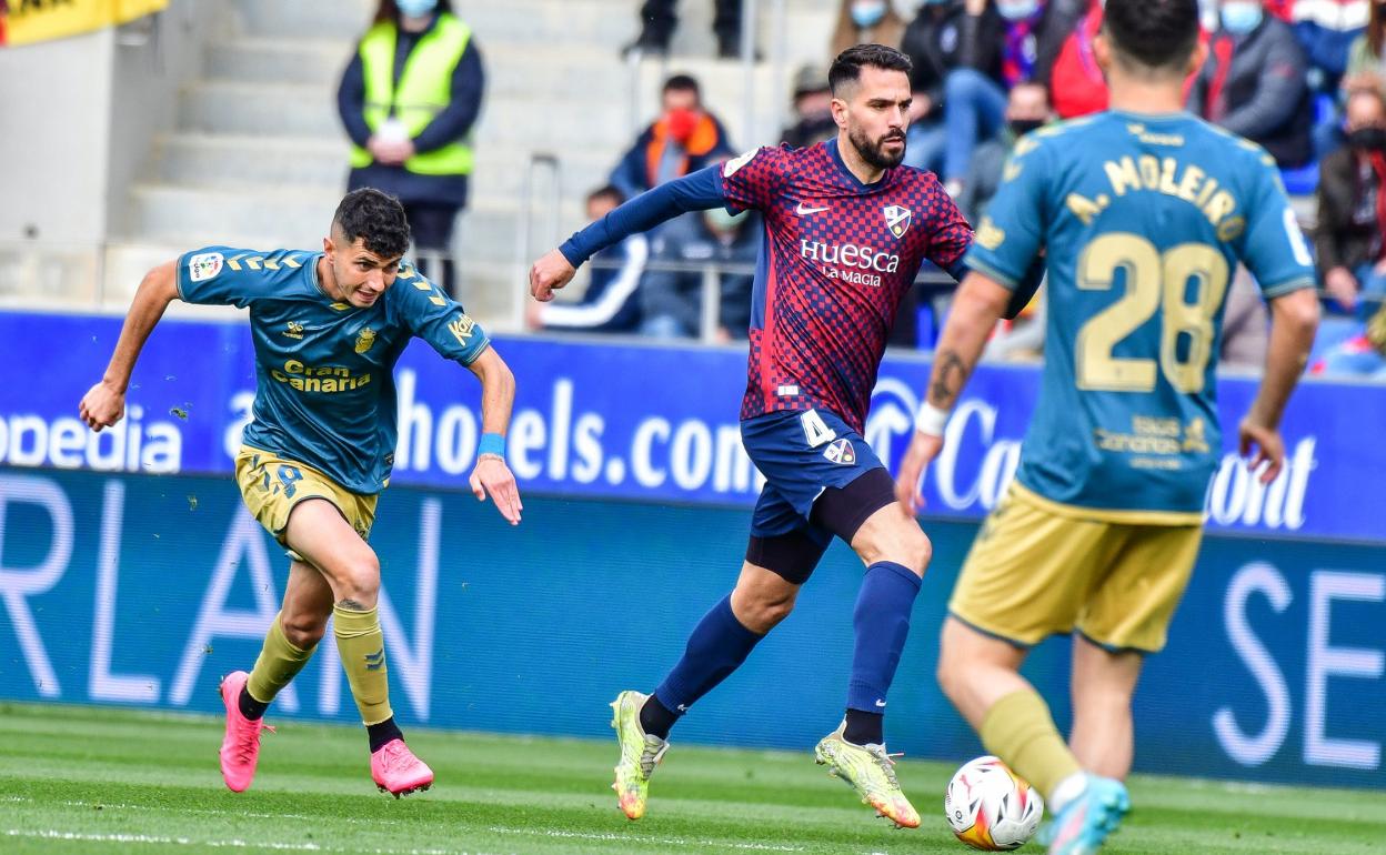 Rafa Mujica persigue a Insúa en el empate contra el Huesca en el Alcoraz. 