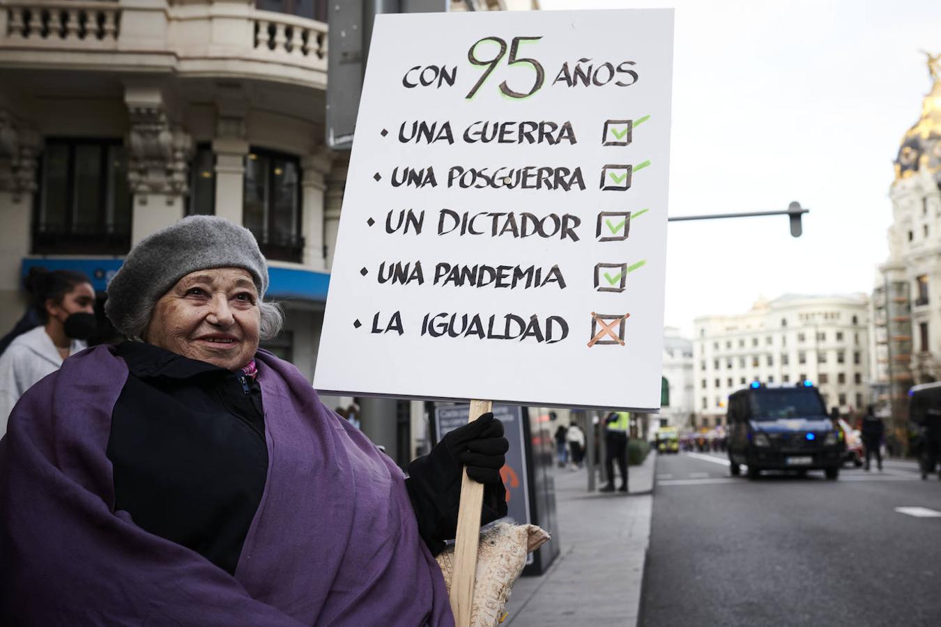 Una mujer porta un cartel en la marcha feminista de Madrid en la que tacha la igualdad como una de las cosas que no se han cumplido en sus 95 años