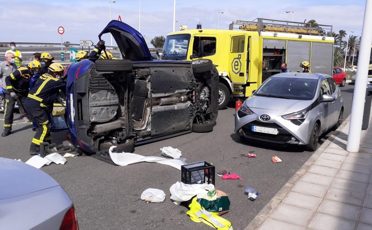 Imagen de un accidente de tráfico con un coche volcado junto a la GC-100. 