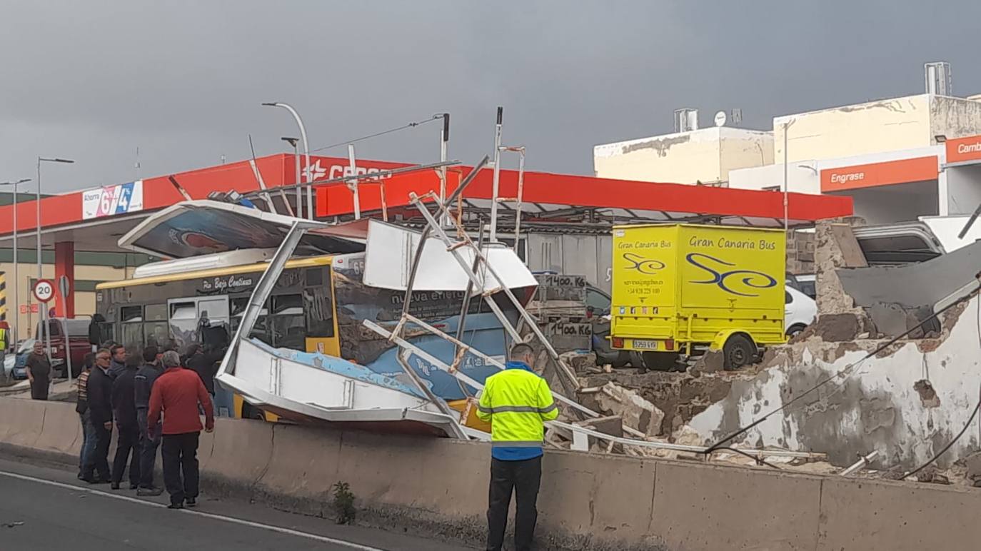 Imagen secundaria 1 - Cae un muro con una valla publicitaria sobre una guagua en El Cardón
