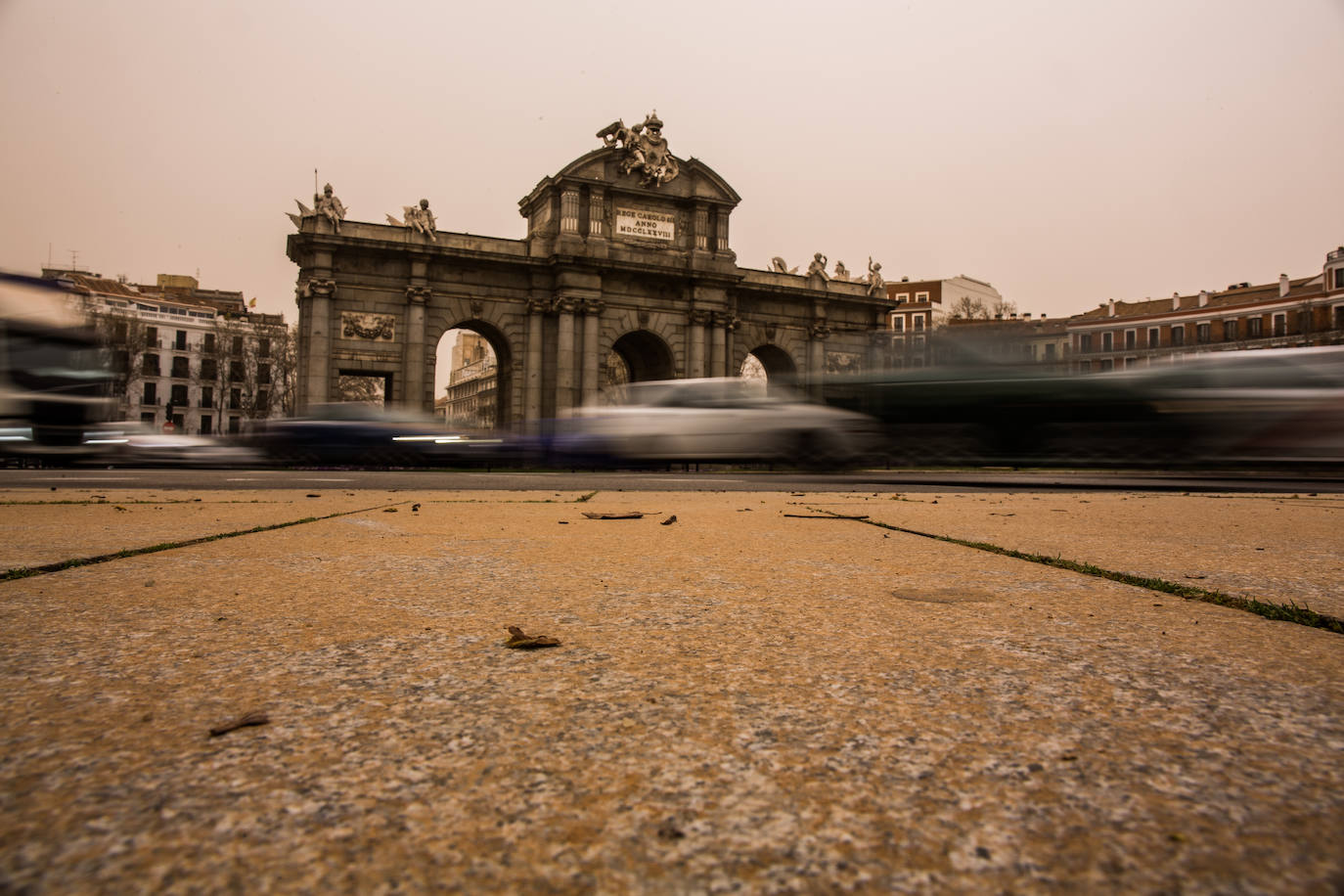 Aceras llenas de arena en la plaza de la Independencia, con la Puerta de Alcalá de fondo.