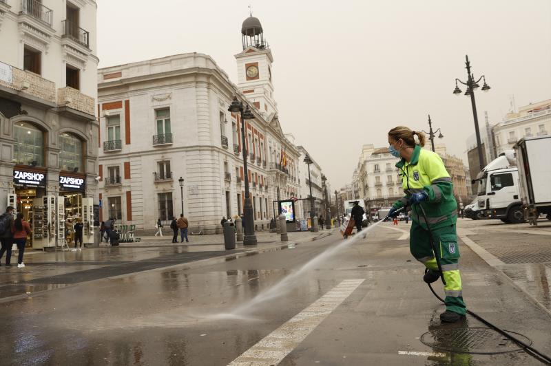 Trabajadores de la limpieza retiran en la Puerta del Sol el polvo en suspensión que proviene del Sáhara.