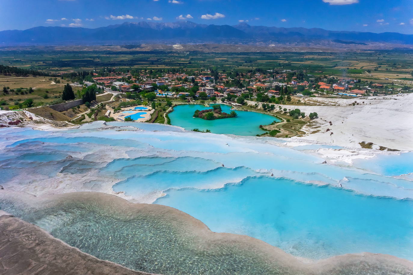 Pamukkale (Denizli, Turquía) | Esta fantasía natural es la principal atracción turística de la región de Anatolia. Cada año atrae a millones de visitantes debido a sus piscinas naturales, de un blanco inmaculado y con aguas de un intenso color verde esmeralda que vierten, como una inmensa cascada pétrea, hacia el valle inferior.
