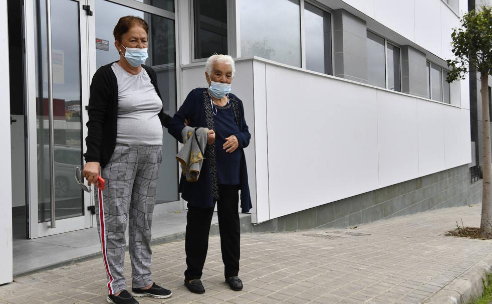 Carmen Saavedra y su hija Juana Hernández posan en la fachada del edificio donde tienen su nueva vivienda desde mayo pero al que no han podido mudarse todavía. 