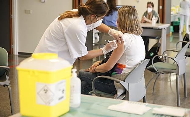 Una sanitaria vacuna contra la covid a una mujer en el Negrín. 