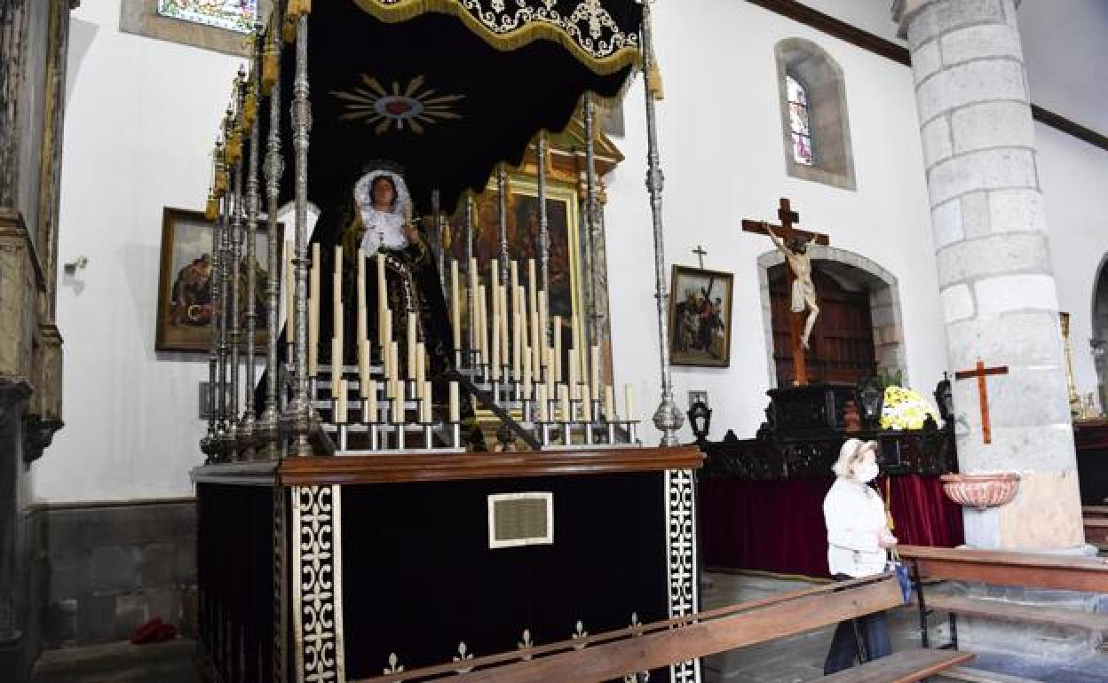 q Los voluntarios, con el sacristán Juan Santana en medio, son los encargados de engalanar los tronos con flores.