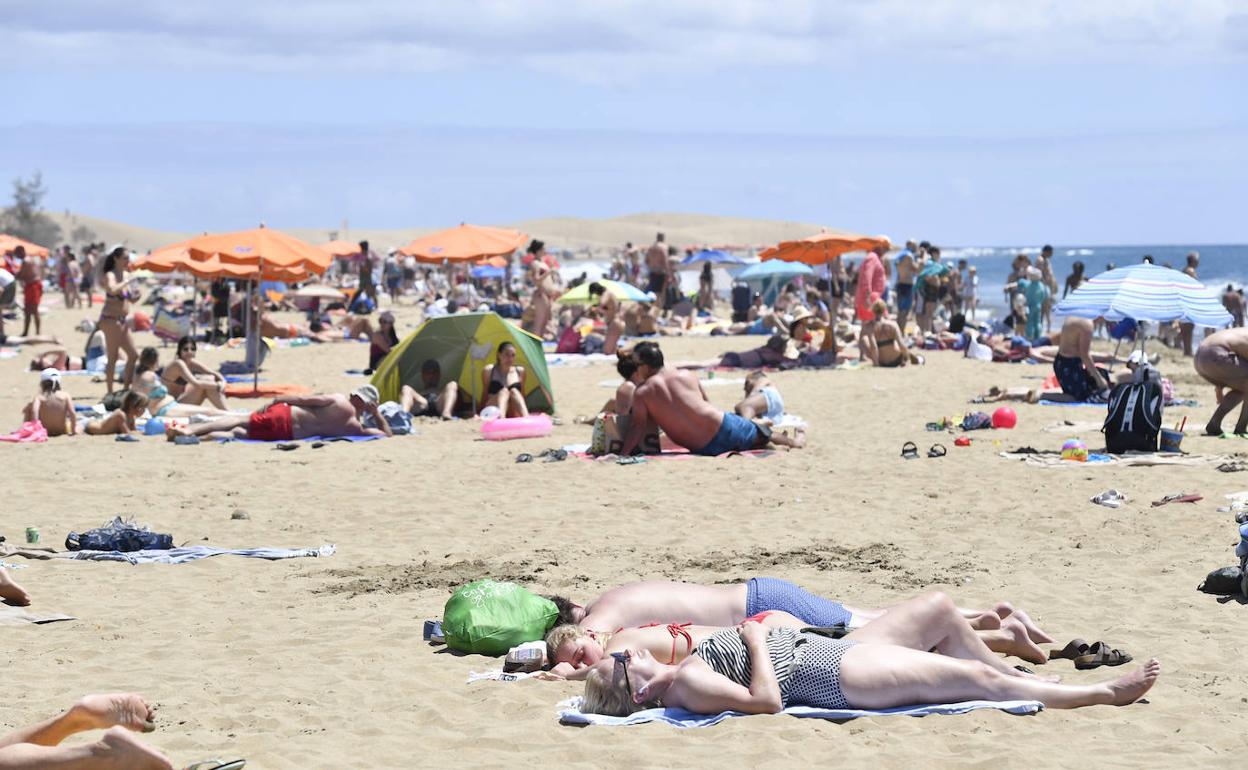 Turistas y residentes compartiendo un día de playa en el sur de Gran Canaria. 