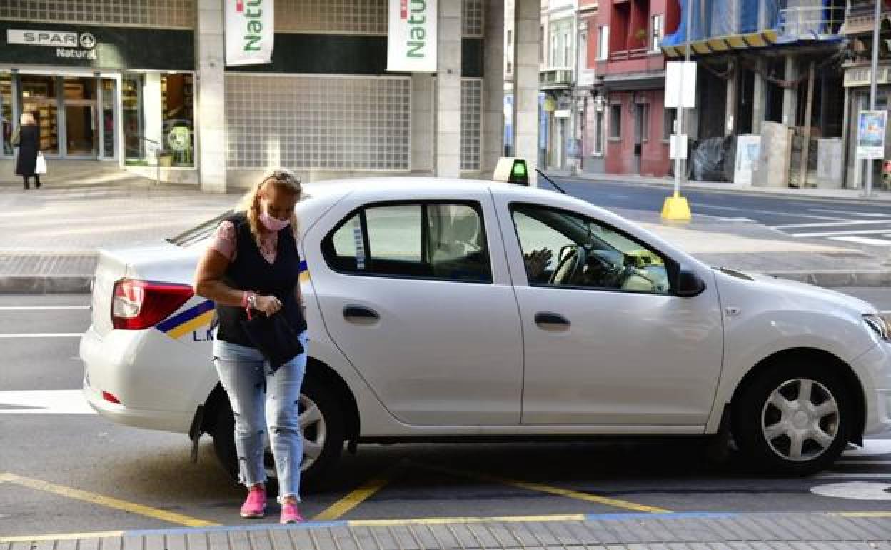 Una ciudadana se baja de un taxi en la capital grancanaria. 