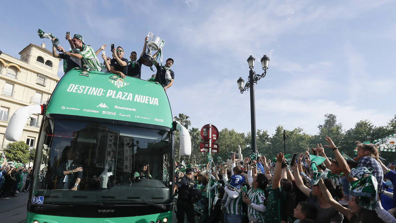 Jugadores del Betis saludan desde el autocar durante su recorrido con destino al ayuntamiento de Sevilla, para celebrar su título de Copa del Rey.