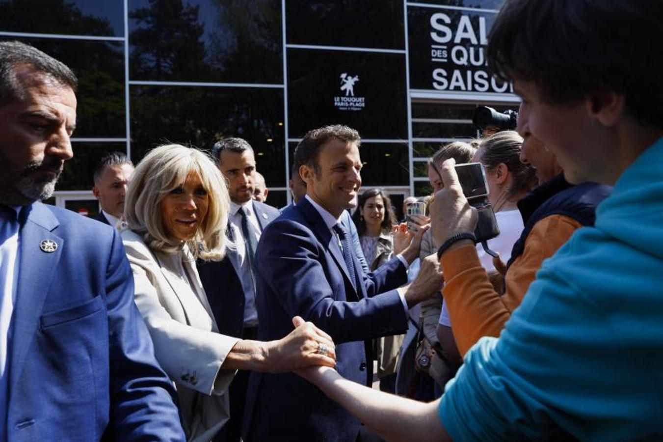 Brigitte Macron y el candidato liberal saludan tras las votación en su centro electoral. 