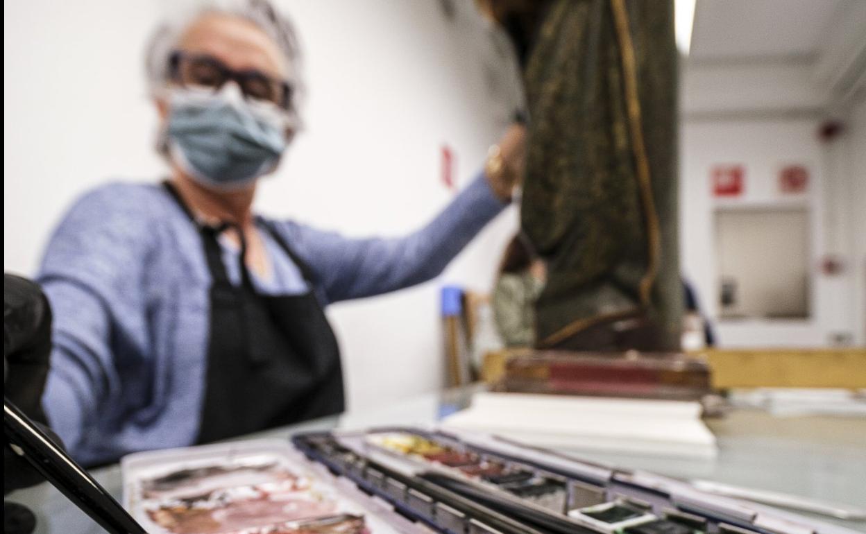 La restauradora Amparo Caballero trabaja con una talla flamenca. 