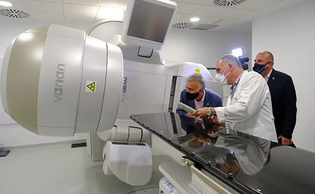 Un técnico explica al presidente canario el funcionamiento del acelerador lineal para tratamientos de oncología. 