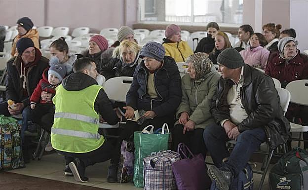 Un voluntario ayuda a un grupo de refugiados en la estación de Odesa. 