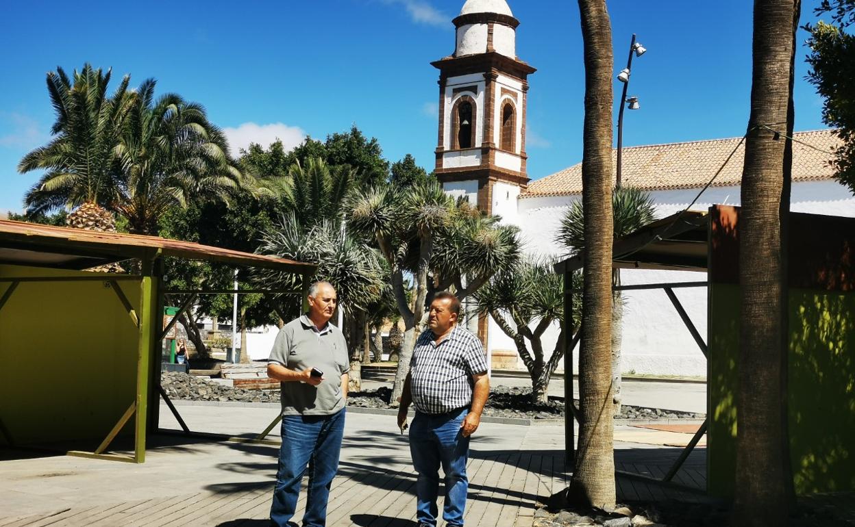 Alcalde y concejal de Cultura, en el montaje de los expositores de la plaza de la iglesia de Antigua. 