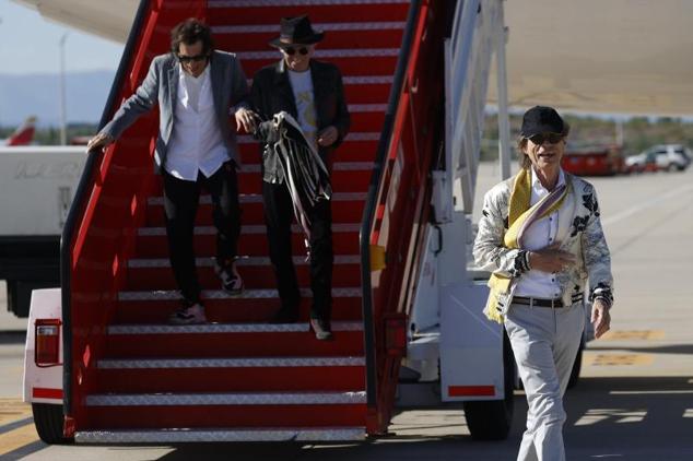 Jagger, en cabeza, baja la escalera del avión delante de Wood y Richards.