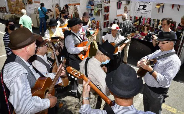 Imagen principal - En la foto superior, una de las 12 parrandas que animarán el paseo de los visitantes por la feria durante el fin de semana. Debajo, los cargos públicos degustando productos locales. Y otro momento de la feria. 