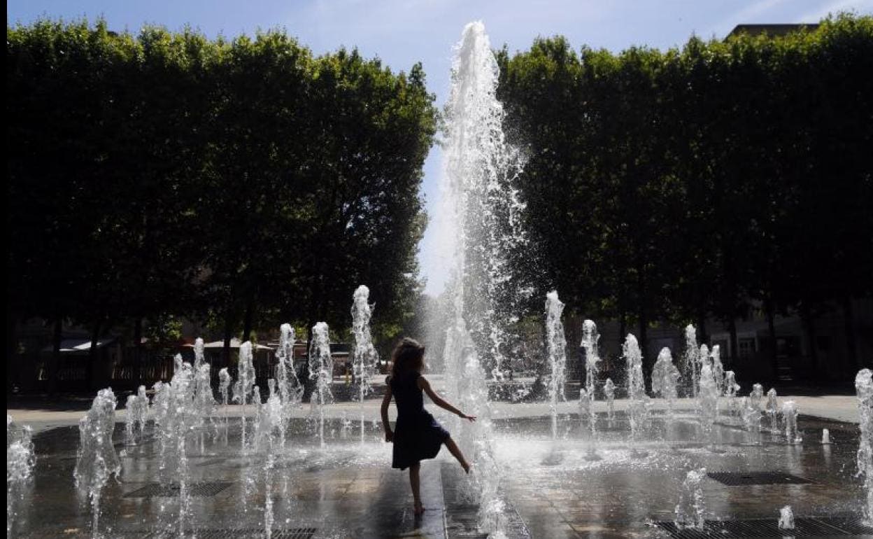 Una niña se refresca en una fuente pública de Montpellier. 