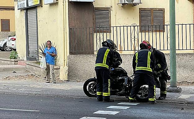 Los bomeros sofocan el incendio que se originó en la moto. 