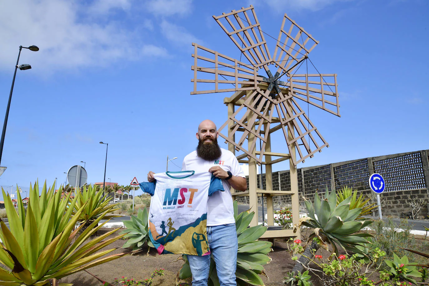 Nelson Alonso muestra la camiseta conmemorativa de la presente edición de la prueba, a la entrada del barrio de La Majadilla. 