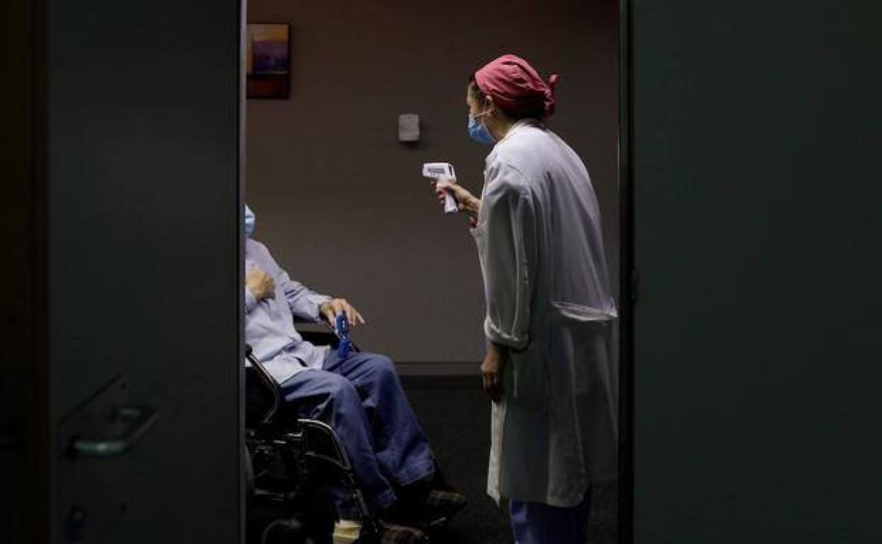 Una enfermera toma la temperatura a un paciente. 