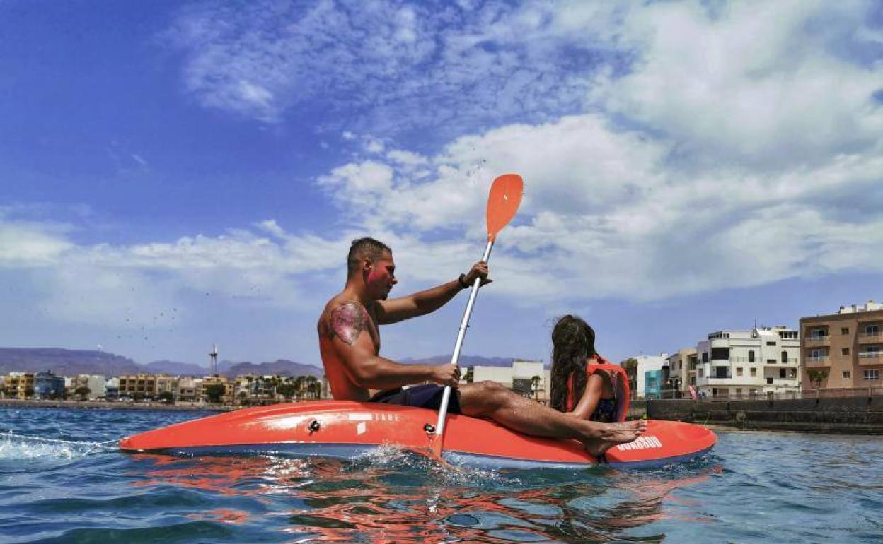 Bañistas se refugian del calor en la playa de Arinaga. 