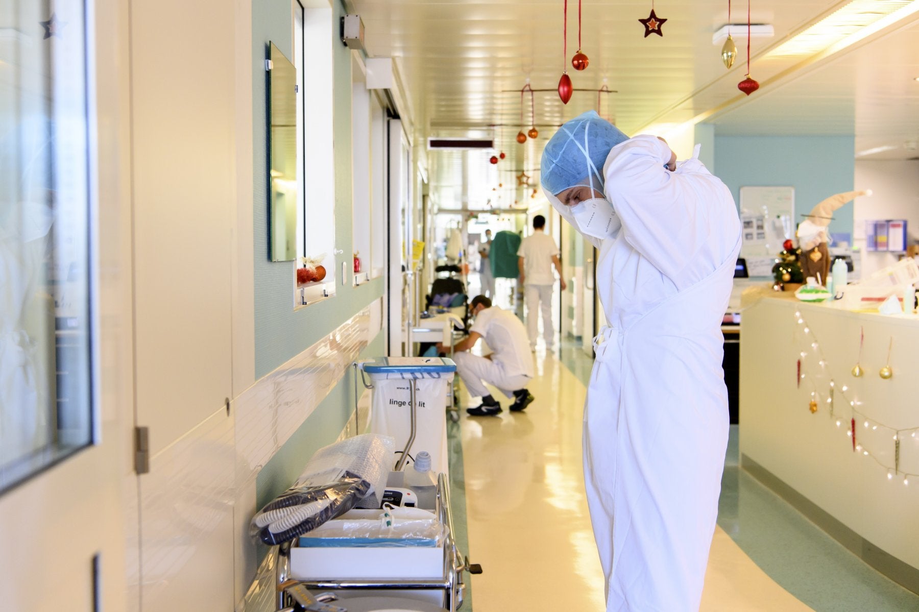 Un sanitario se coloca el traje de protección para atnder a pacientes covid. 