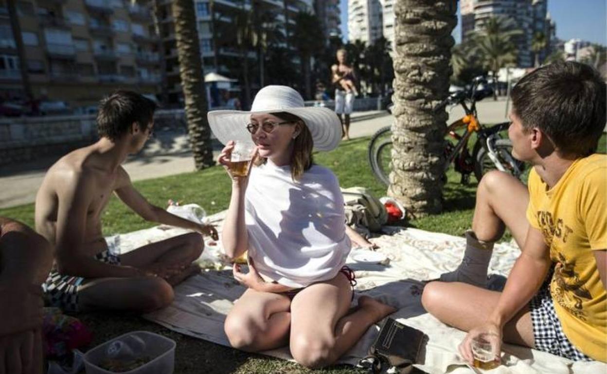 Unos turistas rusos disfrutan del buen tiempo en la playa de la Malagueta, en Málaga. 